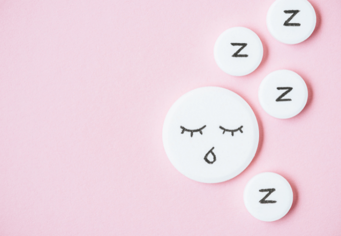 top view of sleeping pills with drawn face and Z signs on pink@LightFieldStudios