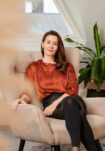 Greta Tanskanen katsoo kameraan ja hymyilee. 