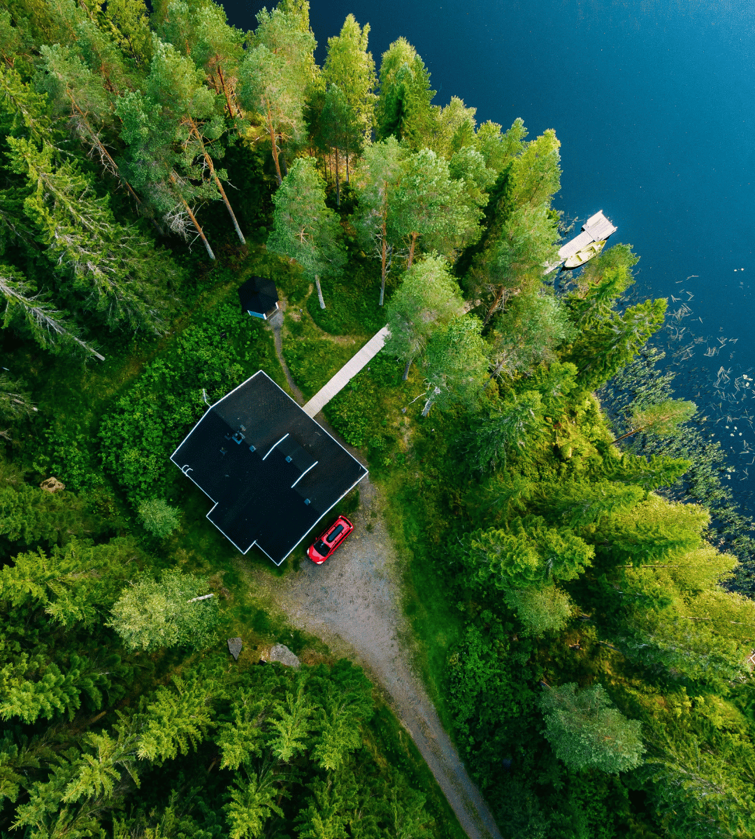 Suomalainen kesämökki järven rannalla ilmasta kuvattuna. 