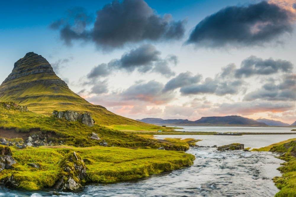 Mountain-waterfalls-below-rocky-peaks-panorama-at-sunrise-Kirkjufell-Iceland