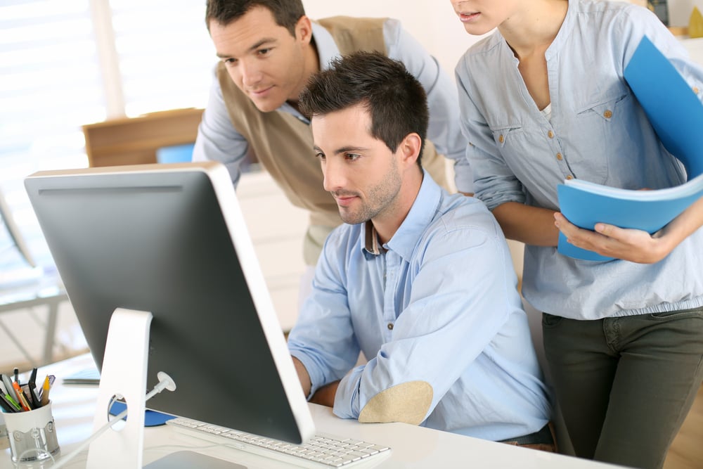 Workteam in office working on desktop computer